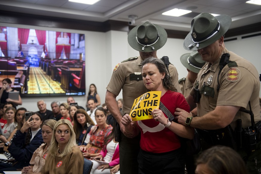 Allison Polidor is escorted out of the room by Tennessee state troopers for holding a sign reading, &quot;1 Kid &gt; All The Guns,&quot; during a special session of the state legislature on public saf ...