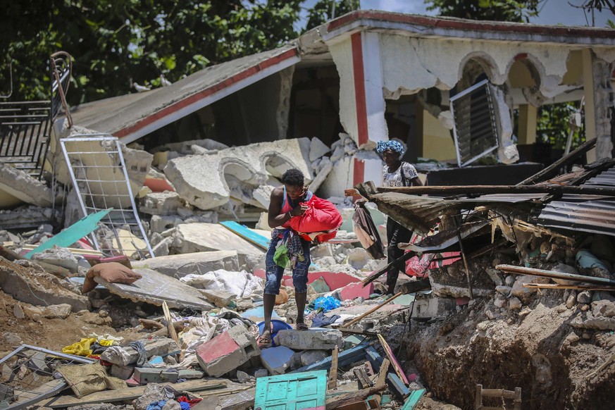 Locals recover their belongings from their homes destroyed in the earthquake in Camp-Perrin, Les Cayes, Haiti, Sunday, Aug. 15, 2021. The death toll from the magnitude 7.2 earthquake in Haiti soared o ...
