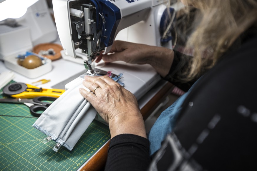 Close-up of Mature Woman Sewing Protective Face Masks With Sewing Machine.