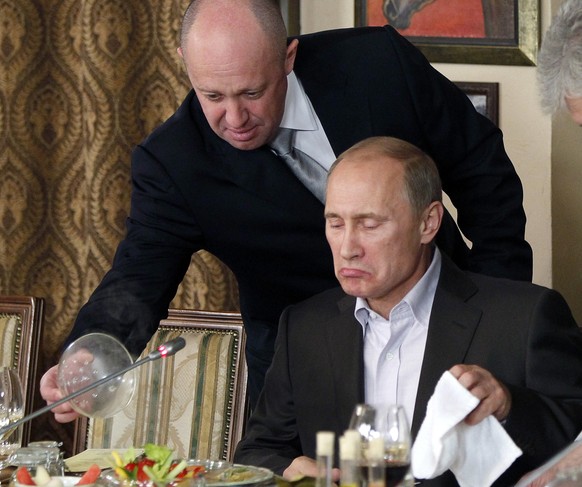 ARCHIV - 11.11.2011, Russland, Moskau: Jewgeni Prigoschin (oben), Chef der Söldnertruppe Wagner, serviert Wladimir Putin, Präsident von Russland, in Prigoschins Restaurant außerhalb von Moskau Essen. ...