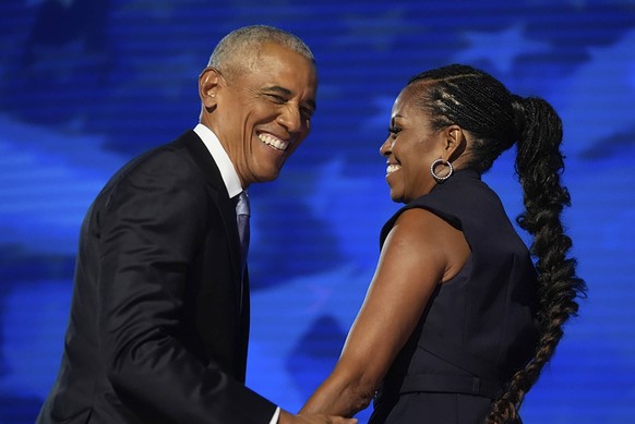 Election 2024 DNC, Former President Barack Obama hugs former first lady Michelle Obama as he is introduced during the Democratic National Convention Tuesday, Aug. 20, 2024, in Chicago. AP Photo/Erin H ...