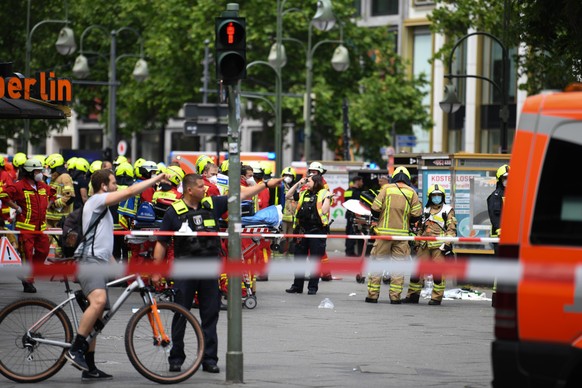 Einsatzkräfte stehen nach einem Zwischenfall auf der abgesperrten Straße. Ein Auto ist in der Nähe der Gedächtniskirche in Berlin in eine Personengruppe gefahren, ein Mensch ist gestorben. Das sagte e ...