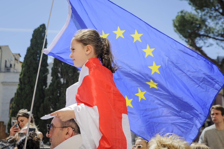 May 5, 2024, Rome, Italy: A little girl on her father s shoulders wears a Georgian flag while in the background the European flag waves during the peaceful protest organized by a group of self-organis ...