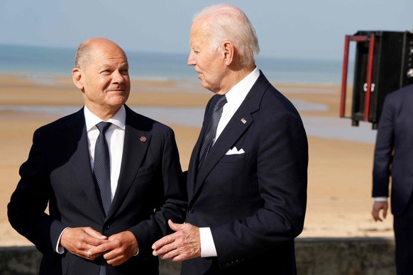 ARCHIV - 06.06.2024, Frankreich, Saint-Laurent-Sur-Mer: Bundeskanzler Olaf Scholz (l) und US-Pr�sident Joe Biden unterhalten sich am Rande der internationalen Gedenkveranstaltung zum 80. Jahrestag des ...