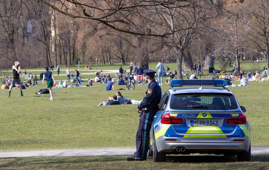 Englischer Garten Spaziergang Natur auf der Wiese liegen Polizei kontrolliert die Corona Situation / Menschen gehen am Sonntag bei sch