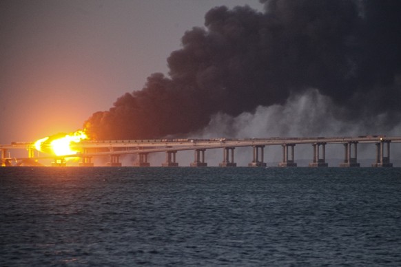 FILE - Flame and smoke rise from Crimean Bridge connecting Russian mainland and Crimean peninsula over the Kerch Strait, after what Russian authorities said was a bomb caused fire and partial collapse ...
