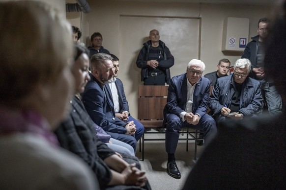 25.10.2022, Ukraine, Korjukiwka: Bundespräsident Frank-Walter Steinmeier (M) wartet nach einem Luftalarm im Luftschutzbunker und spricht mit Bewohnern der Stadt und lässt sich ihre Erfahrungen erzähle ...