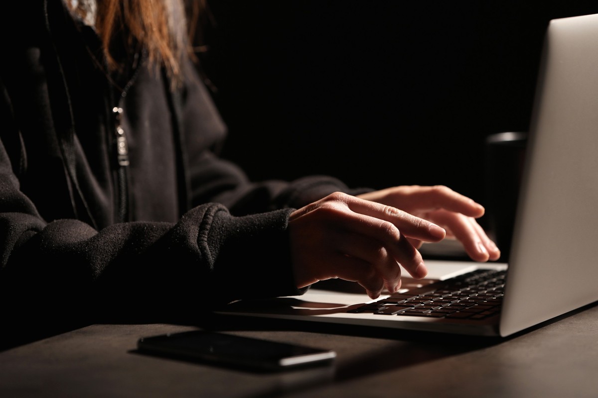 Woman using laptop at table in darkness, closeup. Loneliness concept xkwx addicted, adult, alone, anxiety, app, bored, bullying, cellphone, chat, closeup, computer, concept, darkness, dating, depresse ...