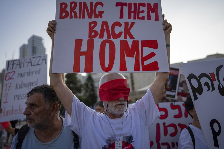 02.11.2023, Israel, Tel Aviv: Bewohner des Kibbuz Kfar Azza fesseln sich die Hände und tragen Augenbinden während einer Solidaritätsdemonstration mit Freunden und Verwandten von Menschen die im Gazast ...