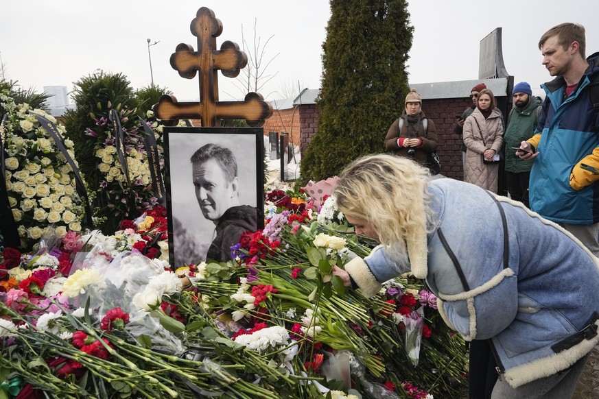 02.03.2024, Russland, Moskau: Eine Frau legt einen Tag nach der Beerdigung von Alexej Nawalny auf dem Borisowskoje-Friedhof Blumen am Grab ab. Nawalny, der der schärfste Gegner von Präsident Wladimir  ...