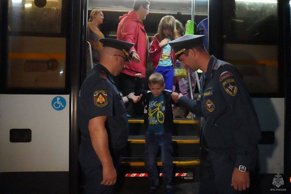 In this photo released by Russian Emergency Situations Ministry press service, people evacuated from a fighting between Russian and Ukrainian forces in Kursk region arrive to a temporary residence cen ...