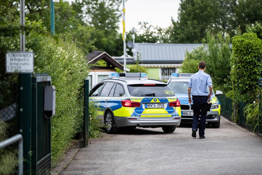 07.06.2020, Nordrhein-Westfalen, Münster: Zwei Polizeiautos stehen in der Einfahrt zu einer Kleingartenkolonie. Eine Laube in der Kolonie ist einer der Tatorte des vermutlichen Haupttäters in einem Mi ...