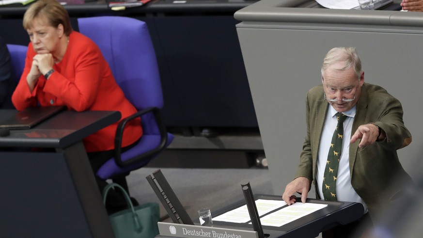 German Chancellor Angela Merkel, left, attends the speech of Alexander Gauland, co-faction leader of the Alternative for Germany party, right, during a budget debate as part of a meeting of the German ...
