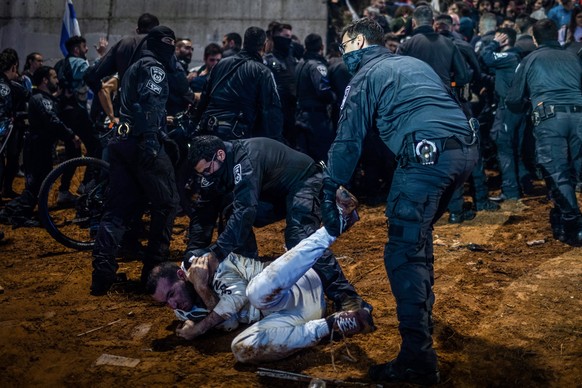 dpatopbilder - 27.03.2023, Israel, Tel Aviv: Die israelische Polizei verhaftet einen Demonstranten während eines Massenprotests gegen die Regierung nach Netanjahus Entlassung von Verteidigungsminister ...