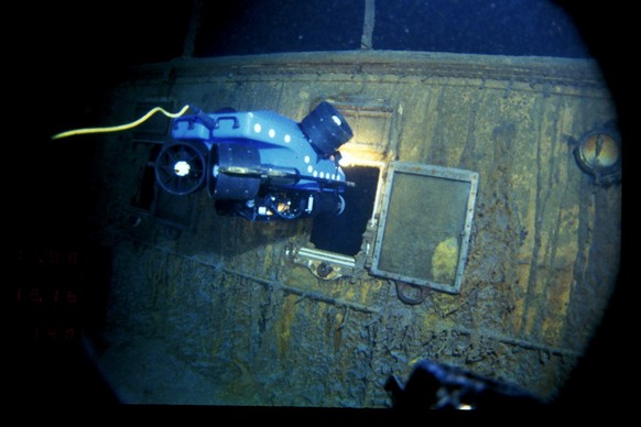In this image provided by the Woods Hole Oceanographic Institution, an underwater remote vehicle examines an open window of the Titanic 12,500 feet (3.8 kilometers) below the surface of the ocean, 400 ...