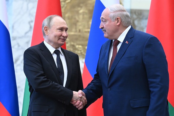 ARCHIV - 24.05.2024, Belarus, Minsk: Auf diesem von der staatlichen russischen Nachrichtenagentur Sputnik via AP veröffentlichten Foto geben sich der russische Präsident Wladimir Putin (l) und der bel ...