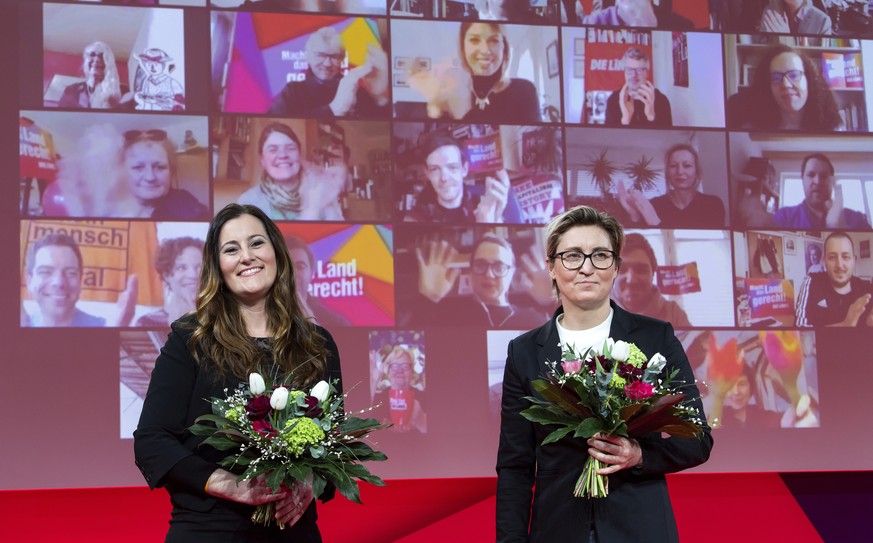 Janine Wissler, left, and Susanne Hennig-Wellsow, the new federal leaders of the Left Party, stand together after their election at the Left Party&#039;s online federal party conference, each holding  ...