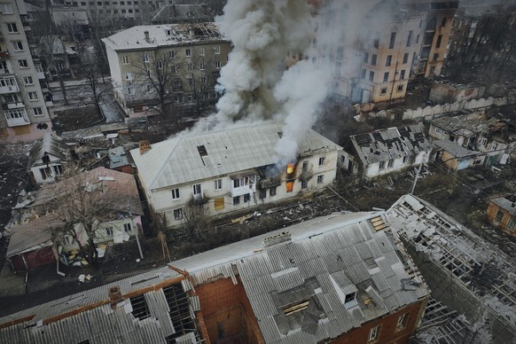26.03.2023, Ukraine, Bachmut: Rauch steigt aus einem brennenden Gebäude in einer Luftaufnahme von Bachmut auf, dem Ort schwerer Kämpfe mit russischen Truppen in der Region Donezk. Foto: Libkos/AP/dpa  ...