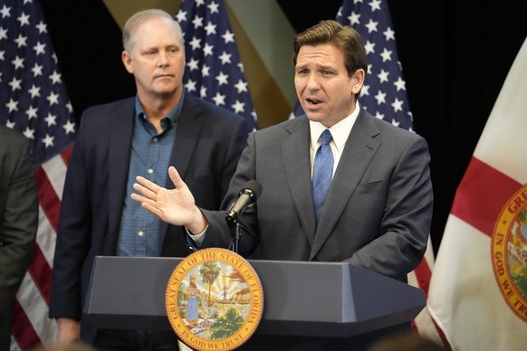 Florida Gov. Ron DeSantis, right, speaks at a news conference as Wilton Simpson, Commissioner of Agriculture listens, at the Reedy Creek Administration Building Monday, April 17, 2023, in Lake Buena V ...