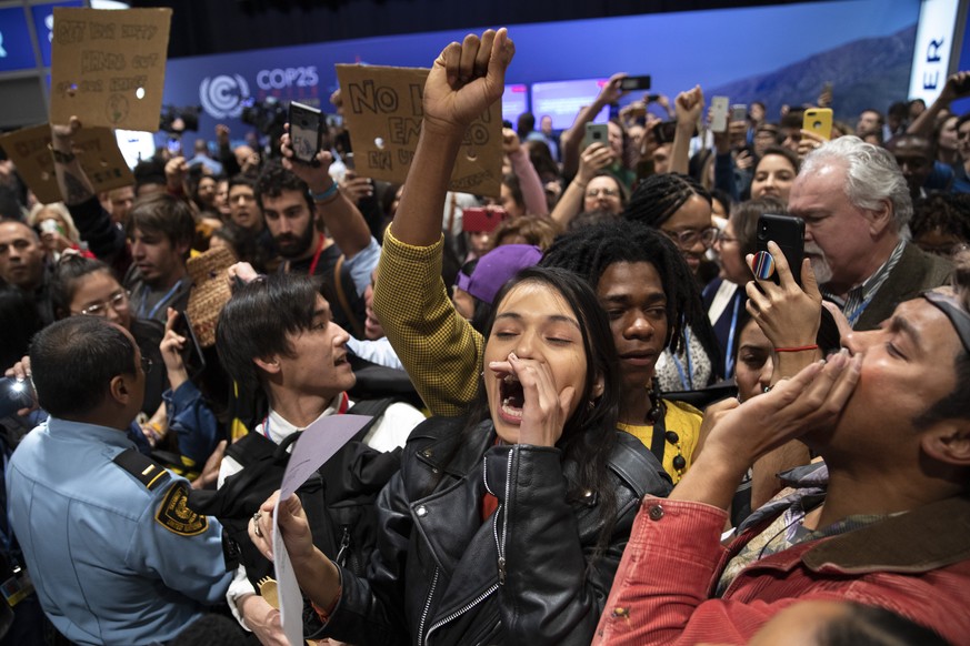 MADRID, SPAIN - DECEMBER 11: Environmental and indigenous activists protest in the hall at the start of a plenary session during the COP25 Climate Conference on December 11, 2019 in Madrid, Spain. The ...