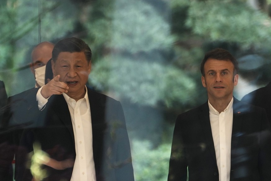 Chinese President Xi Jinping, left, and France&#039;s President Emmanuel Macron arrive for a tea ceremony at the Guandong province governor&#039;s residence in Guangzhou, China, Friday, April 7, 2023. ...