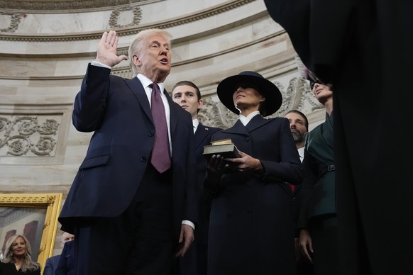 20.01.2025, USA, Washington: Donald Trump wird von Chief Justice John Roberts als 47. Präsident der Vereinigten Staaten vereidigt, während Melania Trump die Bibel während der 60. Amtseinführung des Pr ...