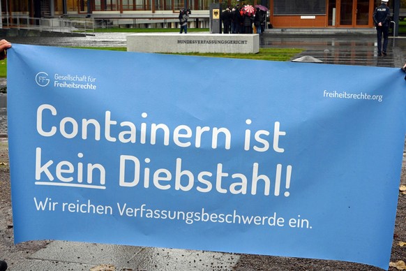 ARCHIV - 08.11.2019, Baden-Württemberg, Karlsruhe: Vor dem Bundesverfassungsgericht wird ein ein Transparent gehalten auf dem steht &quot;Containern ist kein Diebstahl. Justizminister Buschmann (FDP)  ...