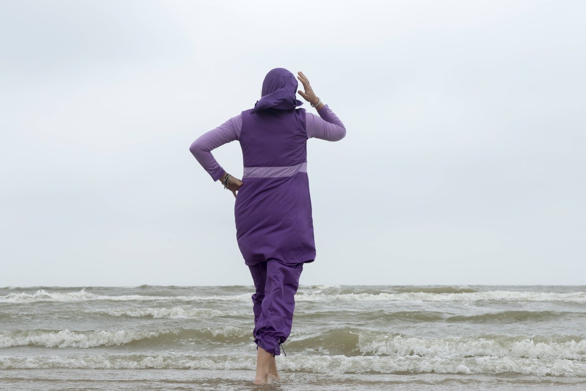 Nederland, Zandvoort, 20160828. Moslima aan het strand in een burkini. Ze kijkt naar de zee. Moslim woman at the beach in burkini, looking at the sea. Model released. Naamsvermelding verplicht. foto:  ...