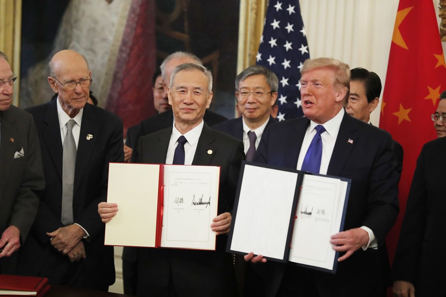 Der stellvertretende chinesische Ministerpräsident Liu He (l.) und der US-Präsident Donald Trump zeigen die unterzeichneten Verträge.