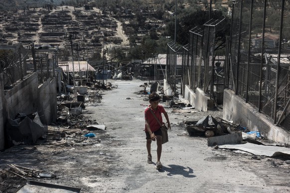LESBOS, GREECE - SEPTEMBER 22: A group of refugees carry their belongings saved from the Moria refugee camp which became unuseable following fires that erupted on September 9, in the Greek island of L ...