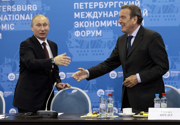 epa03275626 Russian President Vladimir Putin (L) welcomes Germany's former Chancellor Gerhard Schroeder (R) at an economic forum in St.Petersbur, Russia, 21 June 2012. Over 5,000 people from 87 countr ...
