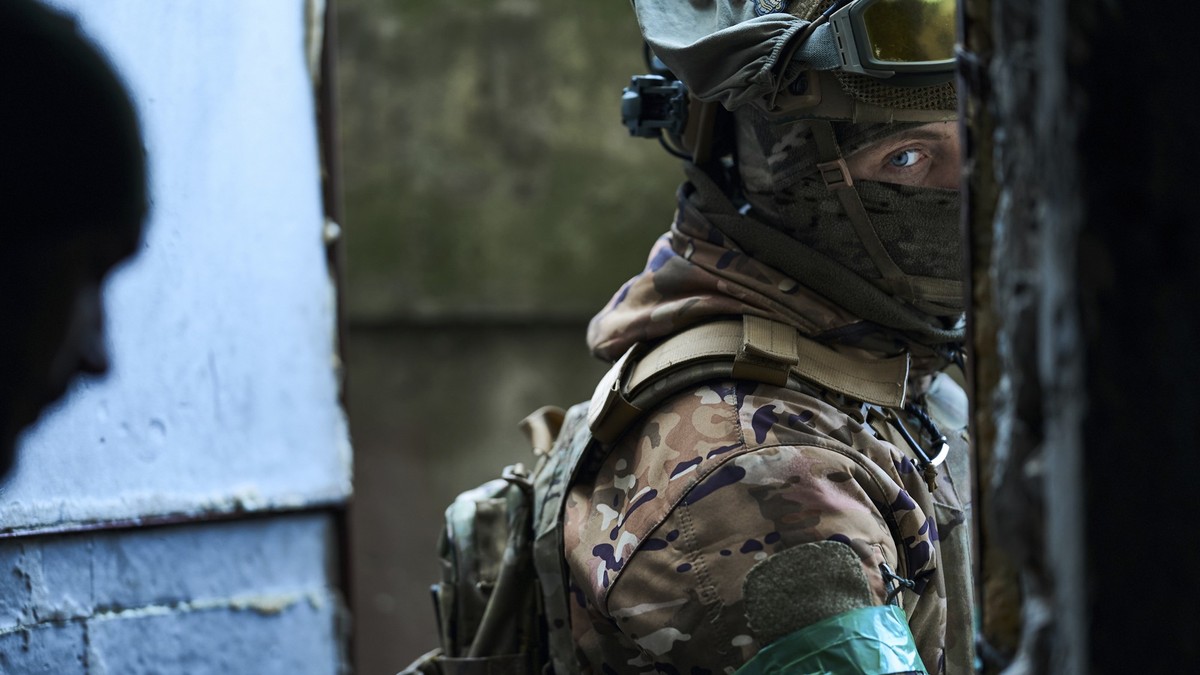 21.02.2023, Ukraine, Bachmut: Ein ukrainischer Soldat schaut aus einem Unterstand. Foto: -/Libkos/AP/dpa +++ dpa-Bildfunk +++