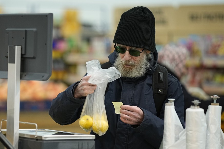 People buy fruits at a hypermarket in Moscow, Russia, on Nov. 3, 2023. The shelves at Moscow supermarkets are full of fruit and vegetables, cheese and meat. But many of the shoppers look at the select ...