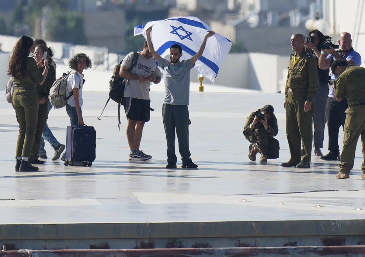 13.10.2025, Israel, Tel Aviv: Nimrod Cohen, eine aus dem Gazastreifen freigelassene Geisel, hält eine israelische Flagge, nachdem er im Ichilov-Krankenhaus aus einem Hubschrauber gestiegen ist. Foto:  ...