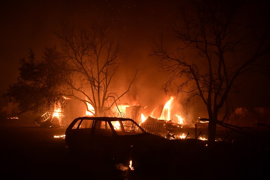 03.08.2021, Griechenland, Athen: Ein Feuer brennt ein Haus nieder. Griechenland wird weiterhin von einer Dauerhitzewelle und Trockenheit heimgesucht, weshalb zahlreiche Waldbr