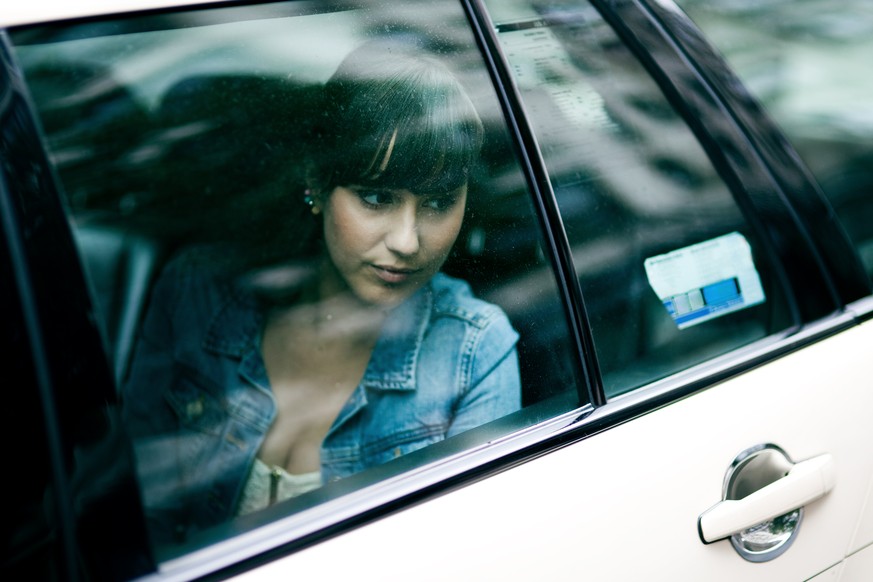 Portrait of a sad young woman sitting in a taxi cab. Berlin, Germany.