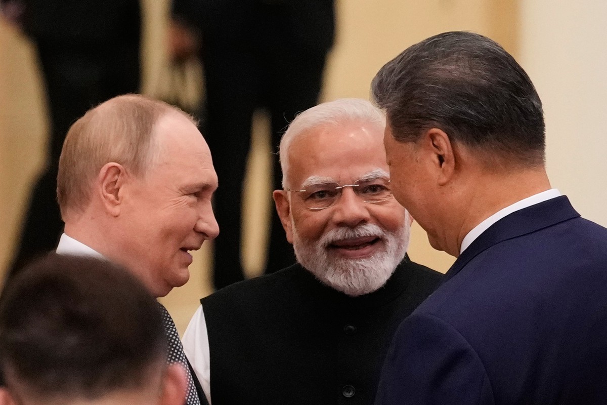 Russian President Vladimir Putin, from left, Indian Prime Minister Narendra Modi and Chinese President Xi Jinping talk ahead of the Shanghai Cooperation Organization (SCO) summit at the Meijiang Conve ...