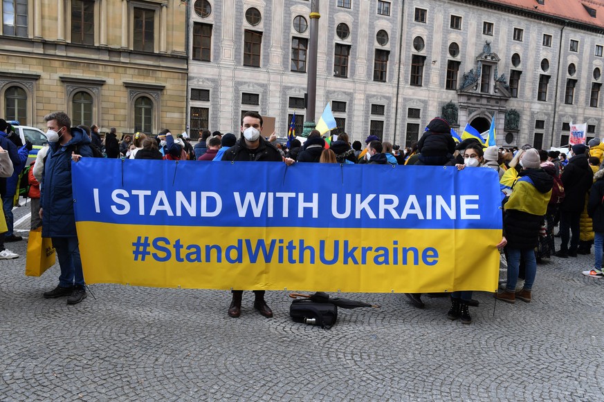 Demonstranten mit einem Plakat &quot;I stand with Ukraine&quot; stehen bei einer Demo für die Ukraine während der Sicherheitskonferenz am Odeonsplatz. Schwerpunkt des dreitägigen sicherheitspolitische ...