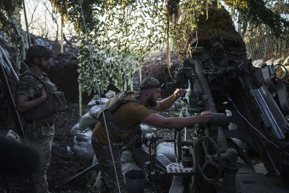 21.08.2024, Ukraine, Region Donezk: Ein ukrainischer Soldat der 148. separaten Artilleriebrigade der Luftangriffstruppen bereitet seine M777-Haubitze vor, bevor er auf russische Stellungen an der Fron ...