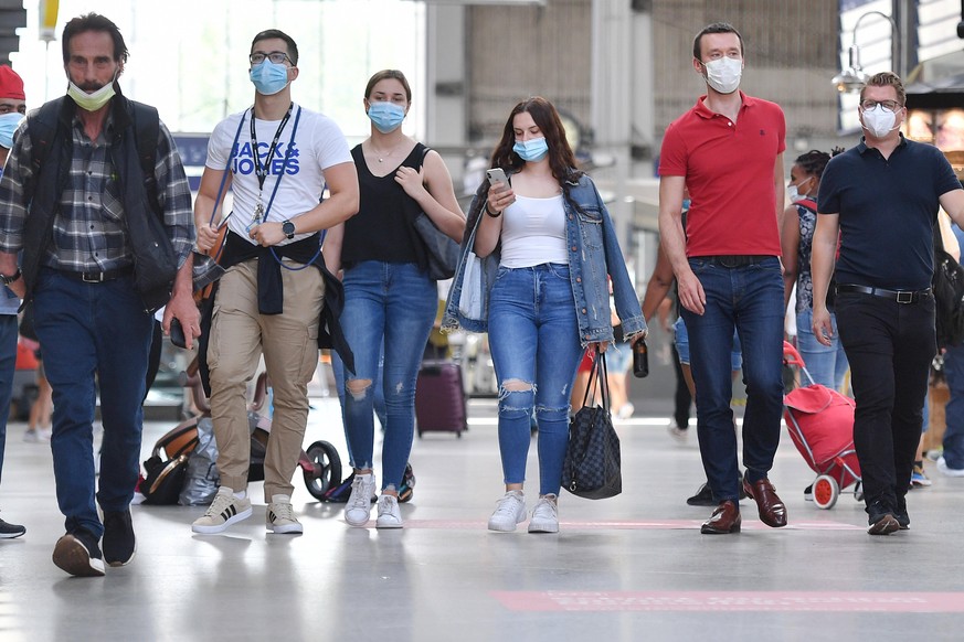 Maskenpflicht im oeffentlichen Personenverkehr. Hauptbahnhof Muenchen am 29.07.2020. Fahrgaeste gehen gehen mit Mundschutz,Maske durch die Bahnhofshalle. Mund-Nasen-Schutz.Munschutz,Maske,Masken, OEPN ...