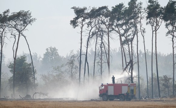 26.07.2022, Brandenburg, Falkenberg: Die Feuerwehr beim L�schen eines Waldbrandes im Landkreis Elbe-Elster. Foto: Sebastian Willnow/dpa +++ dpa-Bildfunk +++