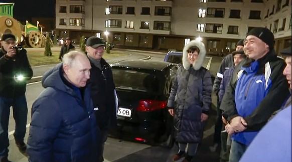 In this photo taken from video released by Russian TV Pool on Sunday, March 19, 2023, Russian President Vladimir Putin talks with local residents during his visit to Mariupol in Russian-controlled Don ...