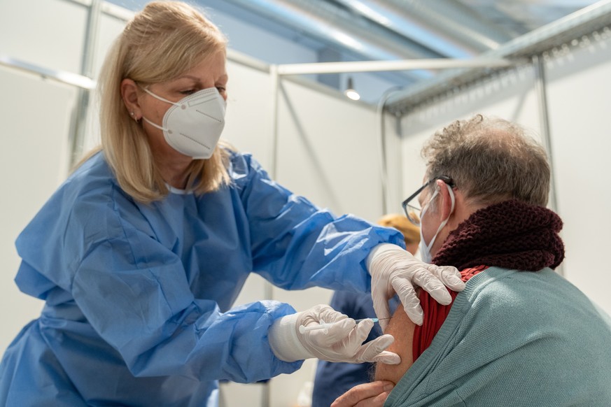17.12.2020, Bayern, Bamberg: Eine medizinische Fachangestellte setzt bei einem Probedurchlauf im Impfzentrum Bamberg bei einem Mann die Kan