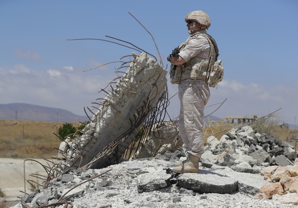 Russian military police officer stands guard near the town of Alhureyeh, Syria, Tuesday, Aug. 14, 2018. The Russian military said Tuesday that its forces in Syria will help U.N. peacekeepers fully res ...