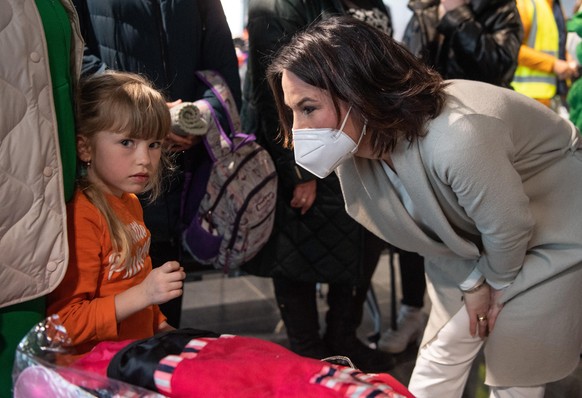 Außenministerin Annalena Baerbock begrüßt ein ukrainisches Kind am Flughafen Frankfurt.