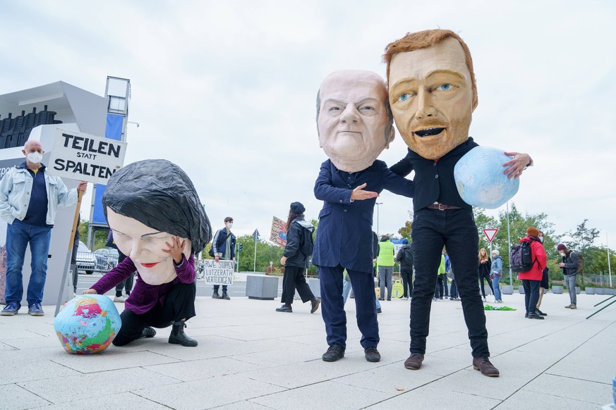 Was bedeuten diese drei für Europa? Aktivisten mit Pappmaché-Figuren der Köpfe von Annalena Baerbock, Olaf Scholz und Christian Lindner am Rande der Sondierungsgespräche von SPD, Grünen und FDP in Berlin. 