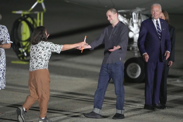 Reporter Evan Gershkovich is greeted on the tarmac by his mother, Ella Milman, as President Joe Biden and Kamala Harris look on at Andrews Air Force Base, Md., following his release as part of a 24-pe ...