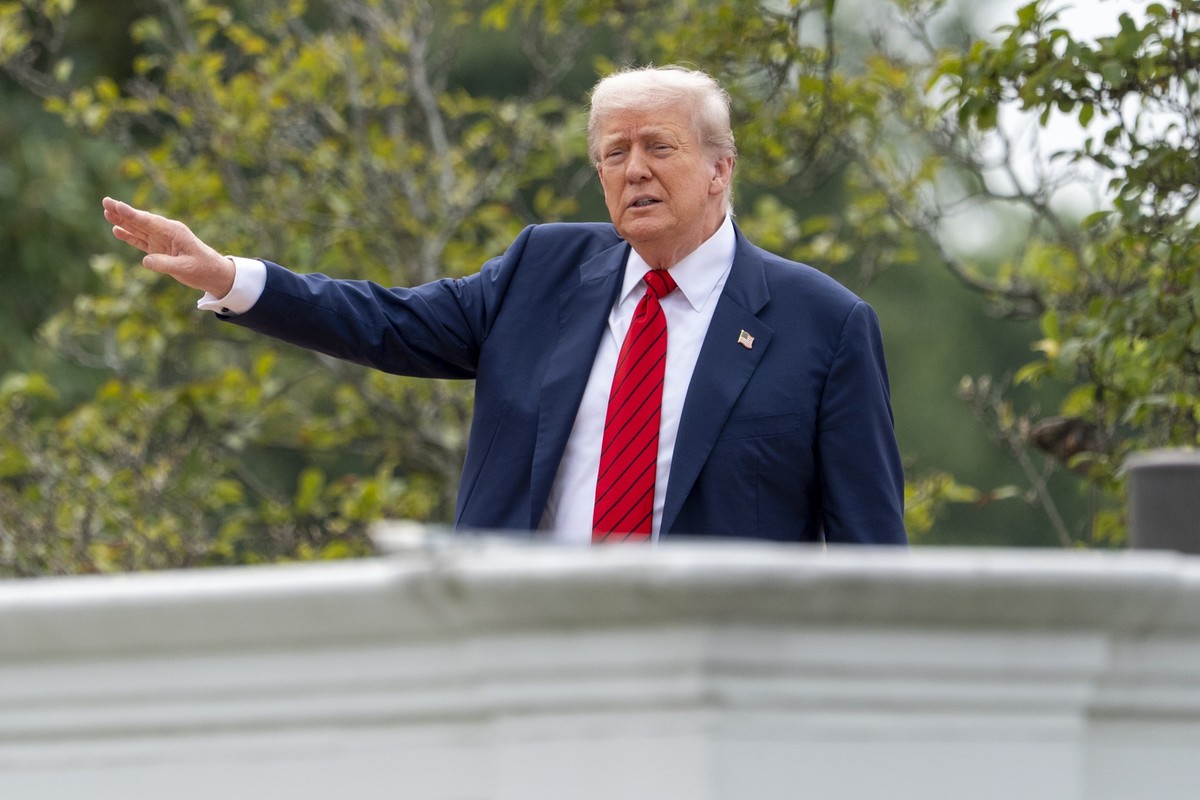 President Donald Trump shouts to reporters as he surveys the grounds from the roof above the Colonnade that goes to the West Wing of the White House, Tuesday, Aug. 5, 2025, in Washington. (AP Photo/Al ...