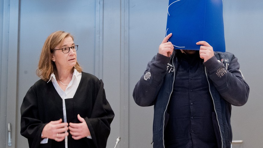 Former nurse Niels Hoegel covers his face as he arrives for the start of his trial in a courtroom in Oldenburg, Germany, October 30, 2018. Julian Stratenschulte/Pool via REUTERS