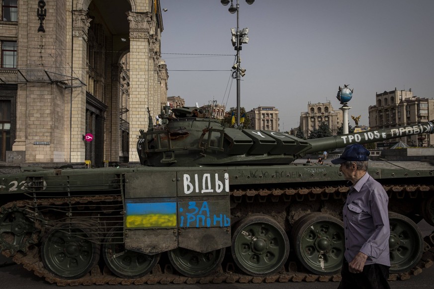 August 23, 2022, Kyiv, Ukraine: An old man walks past the wreckage of a destroyed Russian tank painted with a Ukrainian flag on it in Kyiv. As dedicated to the upcoming Independence Day of Ukraine, an ...
